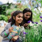 Girl with Easter activity booklet and mother looking at spring flowers in Eden's Med Biome